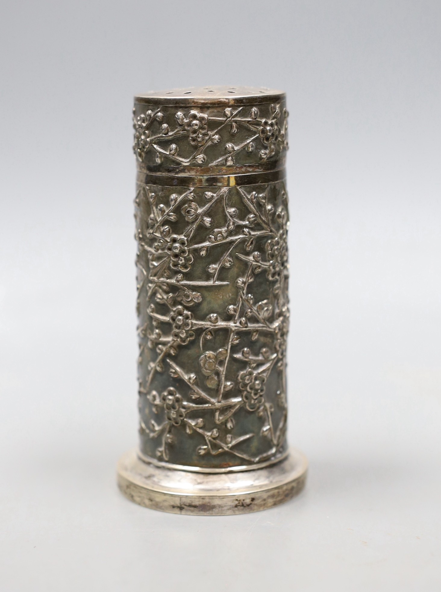 A late 19th/early 20th century Chinese Export white metal cylindrical sugar caster by Wang Hing, Hong Kong, decorated with prunus, 12.1cm, 170 grams.